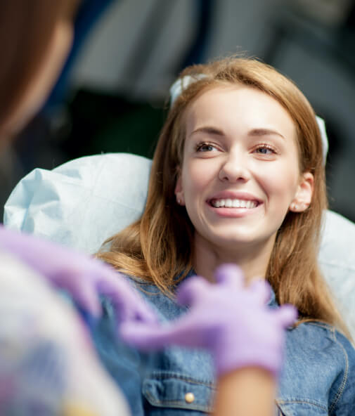 Yougn woman smiling at dentist during dental checkup and teeth cleaning