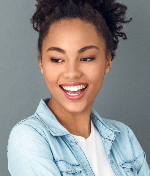 Woman smiling after teeth whitening treatment