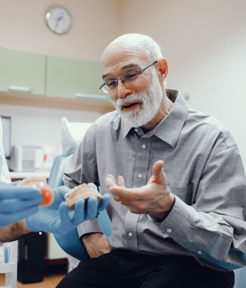 Man discussing the cost of dentures with his dentist