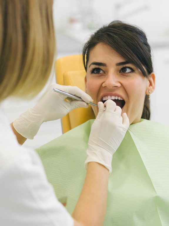 Woman receiving covered dental treatment