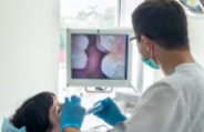Dentist and patient looking at images from intraoral camera