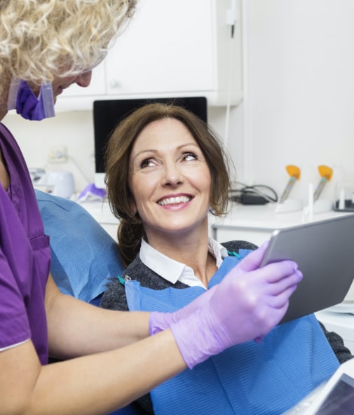 Dentist and patient looking at diagnostic results on tablet computer