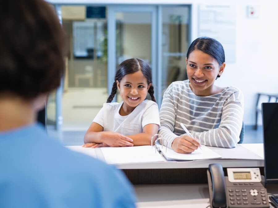 Mother and daughter completing dental insurance claim forms